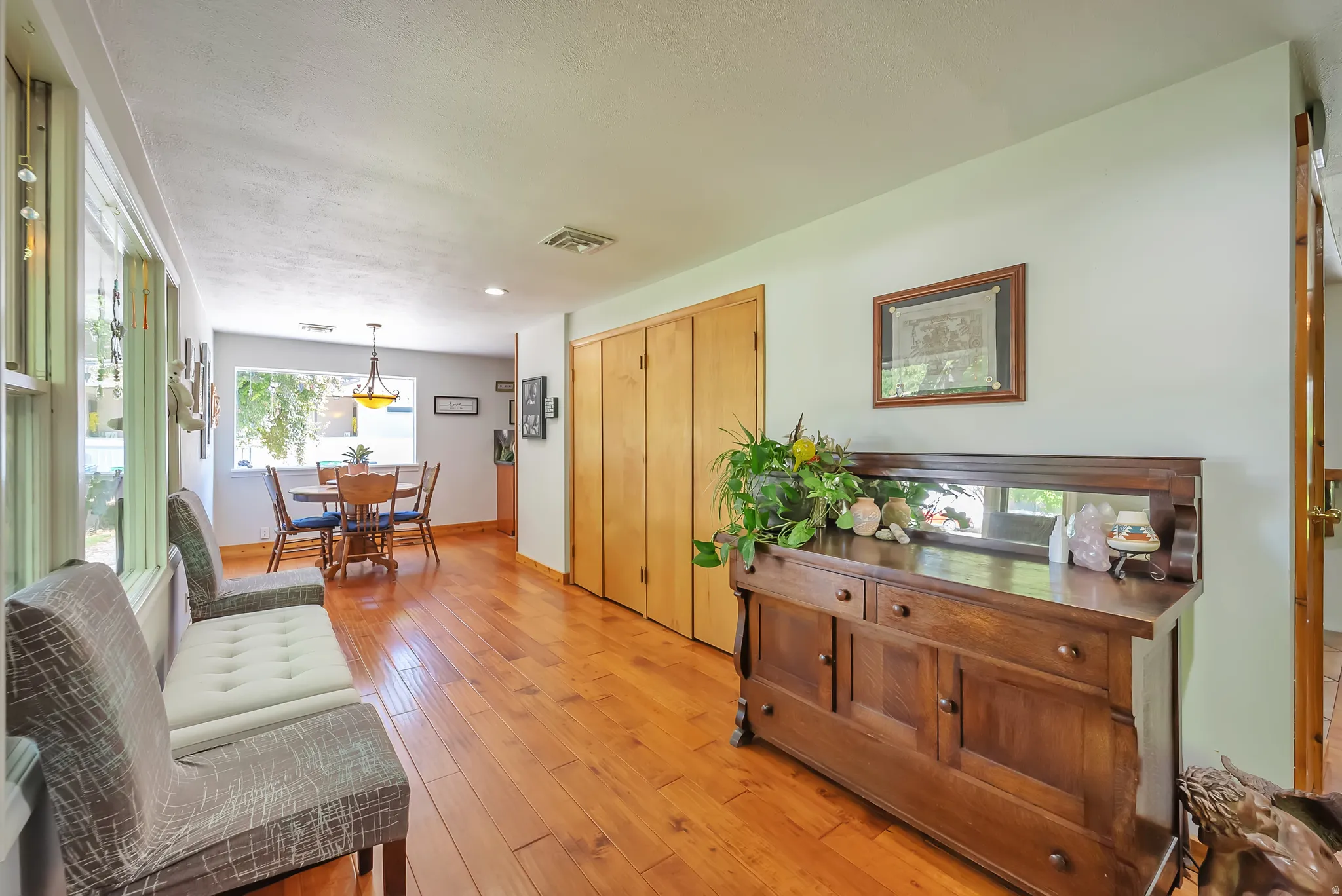 Wood-finish flooring throughout, bright window, recessed lighting, and ample closet storage with bi-fold doors
