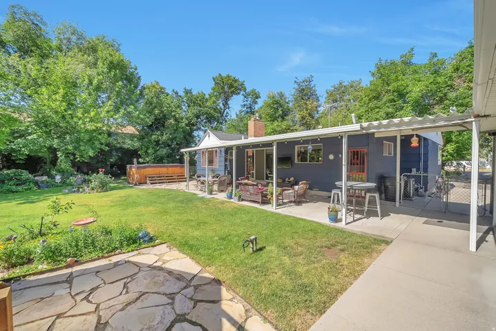 Expansive backyard featuring a covered patio, a flagstone patio, and a hot tub deck