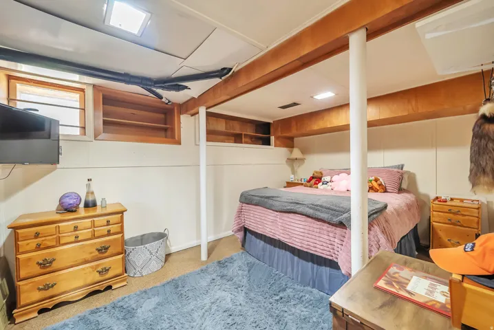 Recessed lighting, wood-finish ceiling beams, wood-framed windows, and built-in shelving