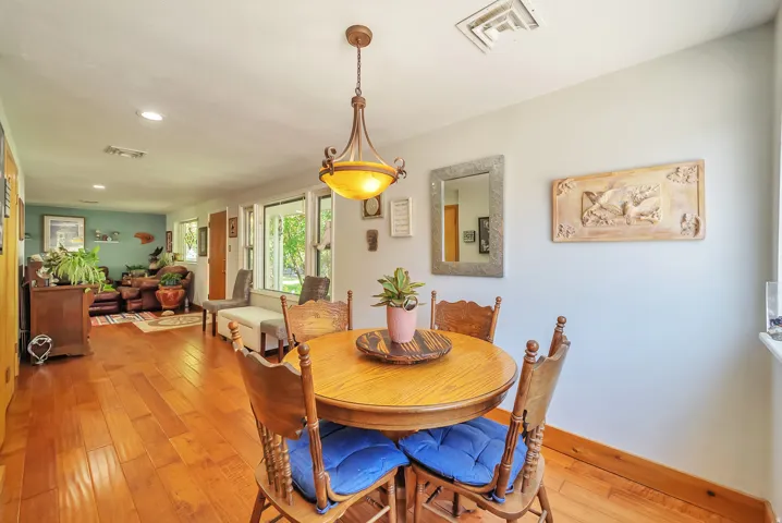 Wood-finish flooring throughout, recessed lighting, and a decorative pendant light fixture