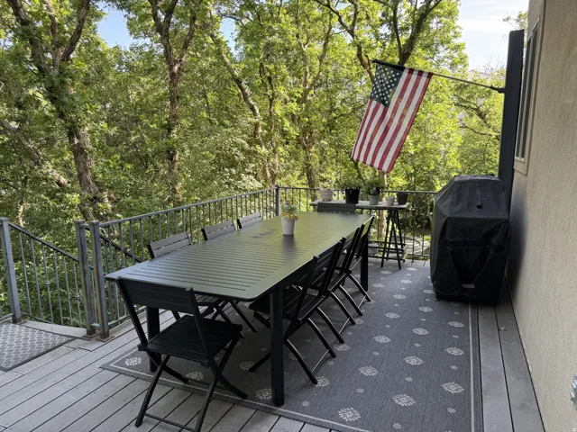 Expansive outdoor deck featuring composite decking, metal railings, and a direct entrance to the property