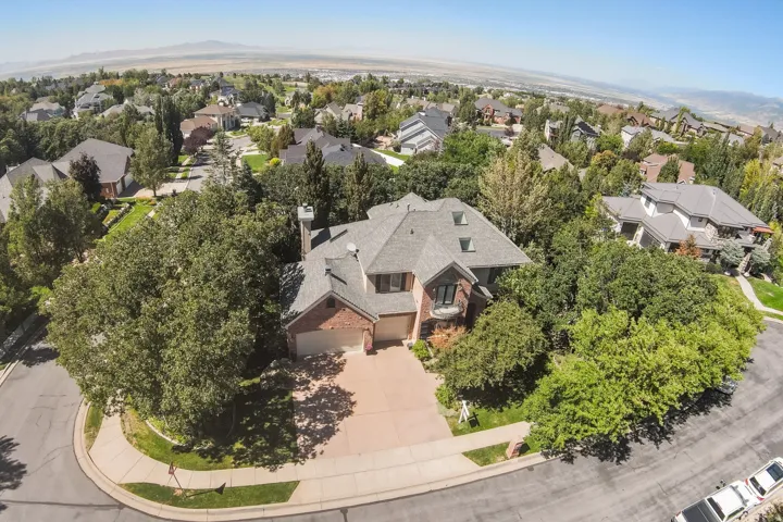 Brick-clad residence with a multi-level roofline, prominent chimney, and a two-car garage