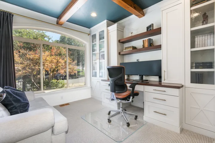 Built-in custom cabinetry with glass-front uppers, wood-finish countertops, and integrated shelving
