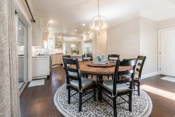 Hardwood flooring, crown molding, spherical chandelier, sliding glass door, and recessed lighting