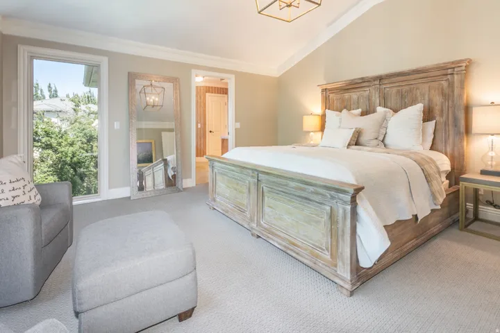 Vaulted ceiling with crown molding, recessed lighting, and a large window