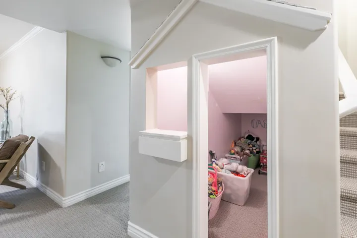 Built-in custom playhouse structure with a window box feature and interior space, adjacent to a carpeted staircase