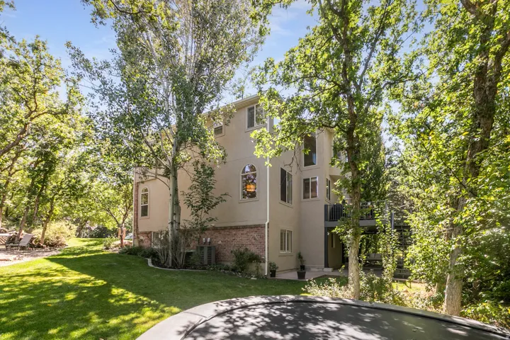 Multi-story exterior with stucco and brick facade, featuring arched windows and multiple rectangular windows