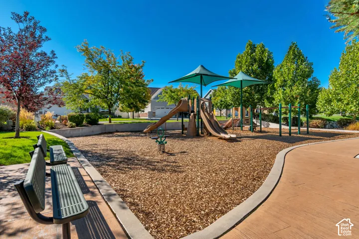 Community park featuring playground equipment, benches, and mature trees