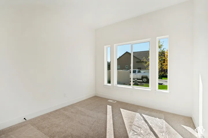 Neutral wall paint, carpet flooring, and multiple windows