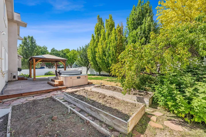 Expansive wood deck with a built-in gazebo, hot tub, and flagstone patio
