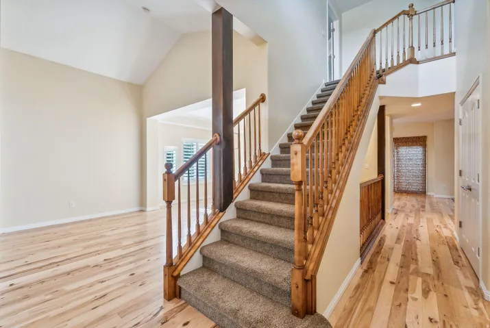 Vaulted ceilings enhance the entry, featuring light wood-finish flooring