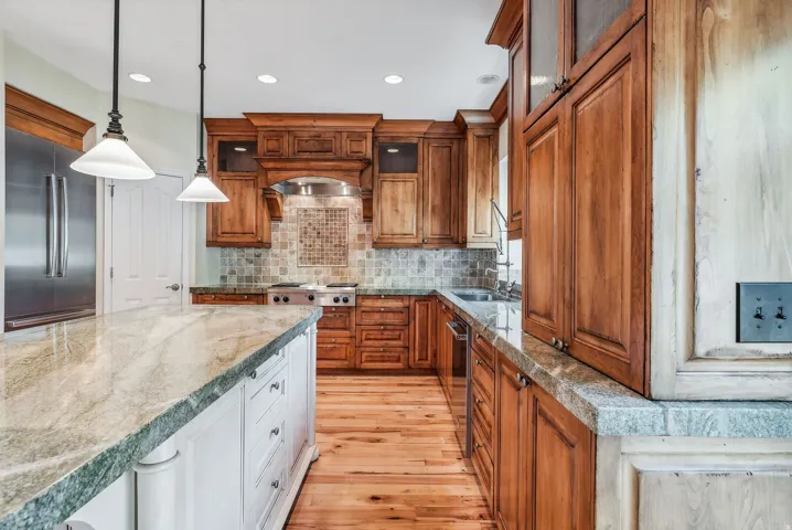 Kitchen with wood cabinetry, stainless steel appliances, and a mosaic tile backsplash