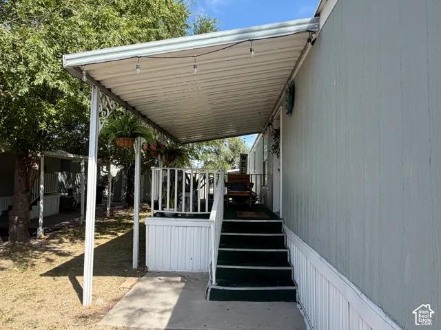 Covered porch with white metal railings and a white corrugated metal roof