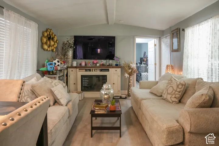 Light wood-finish flooring with a ceiling fan and recessed lighting