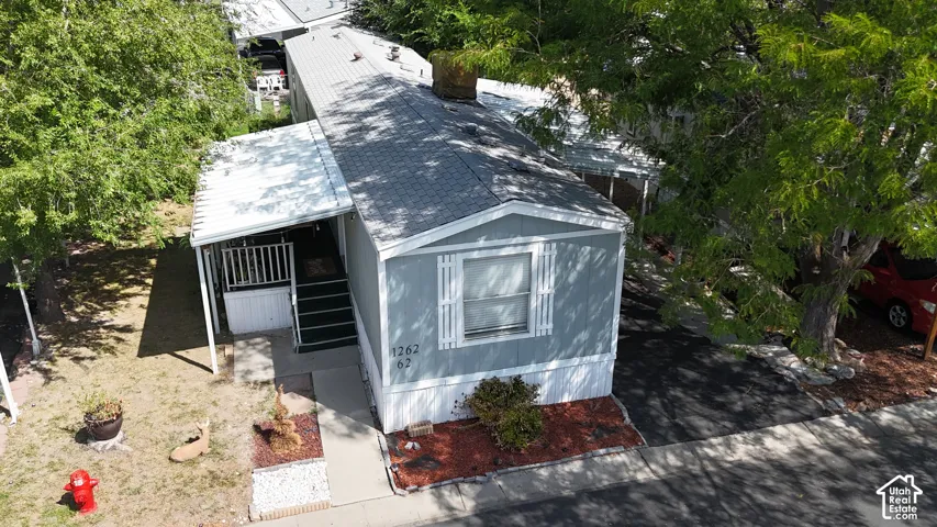 Gray siding exterior with white window trim and a covered entry