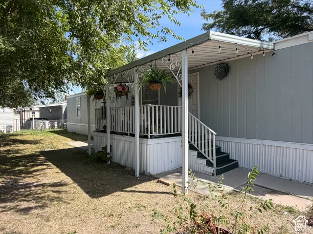 Covered porch with white railings, steps, and exterior siding