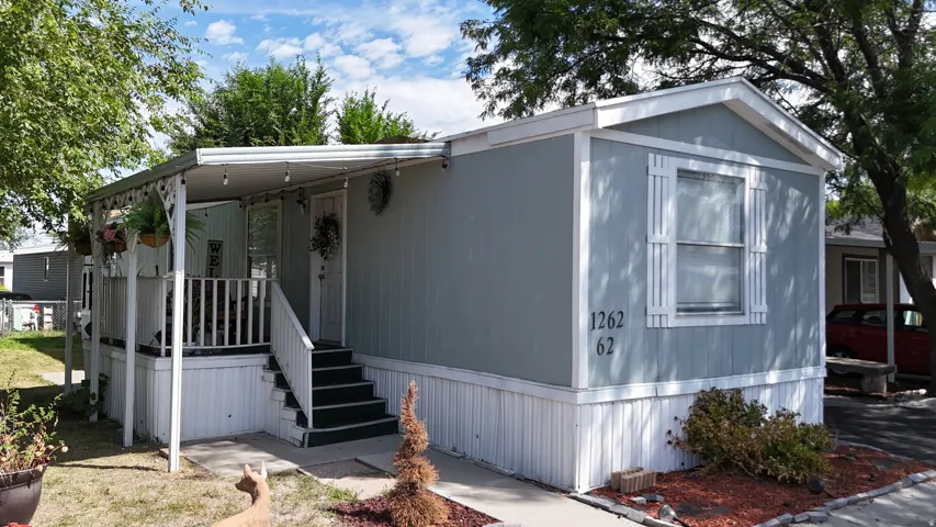 Light blue siding exterior with white trim, covered porch with white railing, and white decorative window shutters