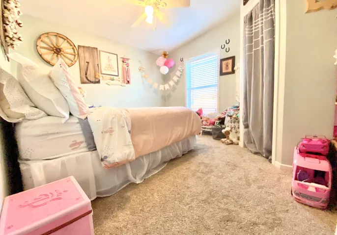 Carpeted flooring with a window featuring blinds and a ceiling fan