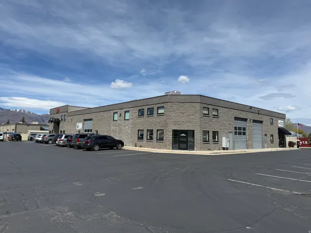 Commercial building with brick exterior, multiple windows, and two large roll-up doors