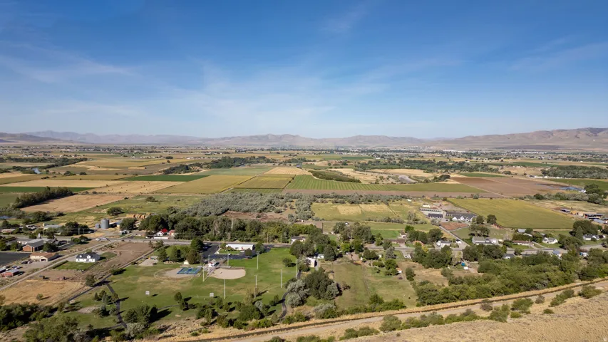 Expansive regional landscape featuring agricultural fields, distant mountains, and scattered residential properties