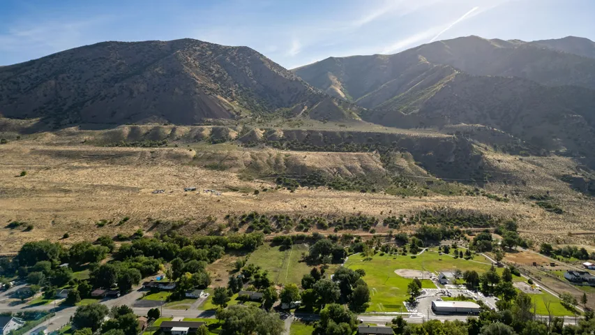 Mountain backdrop, arid terrain, green recreational areas, residential properties, varied landscaping