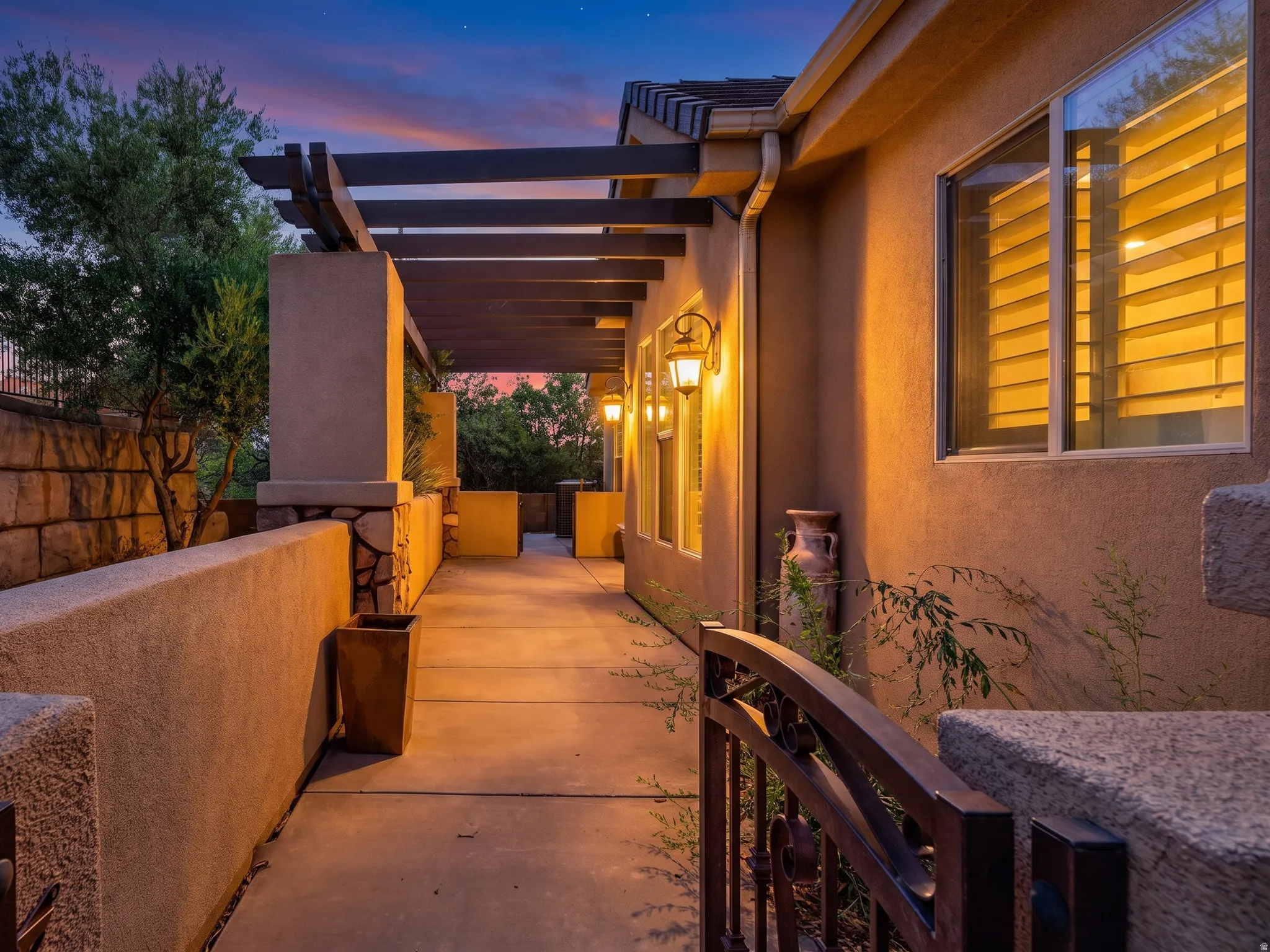 Covered patio with an open lattice pergola and integrated sconce lighting