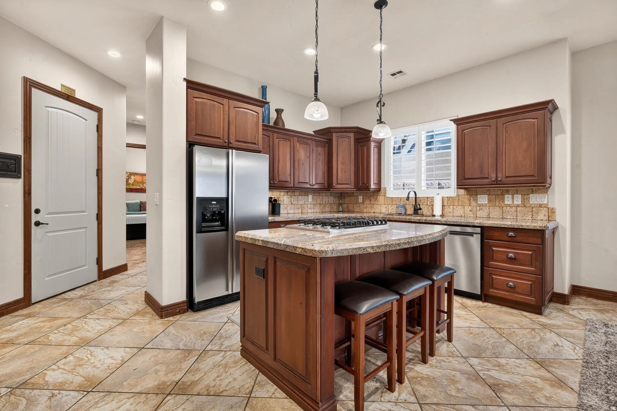 Kitchen featuring a central island with a granite countertop, gas cooktop, and pendant lighting
