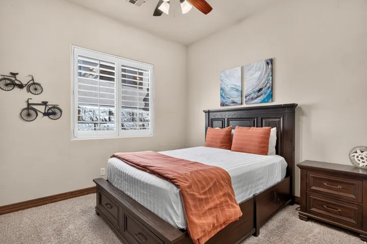 Window with plantation shutters and ceiling fan