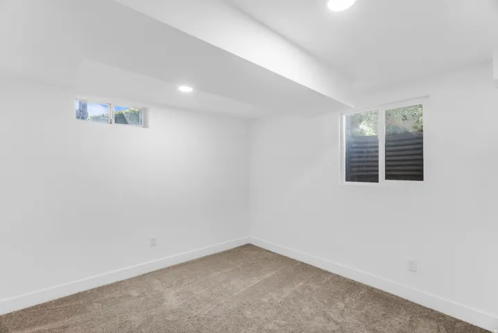 Fourth bedroom with recessed lighting, white walls, two windows, and neutral carpeting