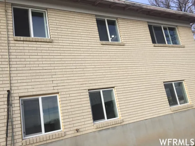 Light-toned brick exterior with white-framed windows and concrete foundation