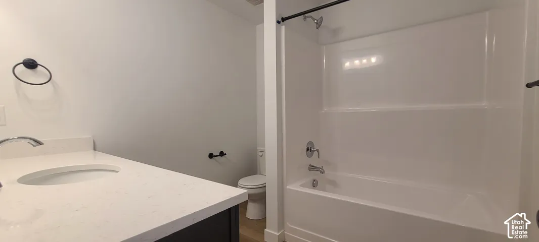 White oval undermount sink set in a light-toned countertop, with a chrome faucet