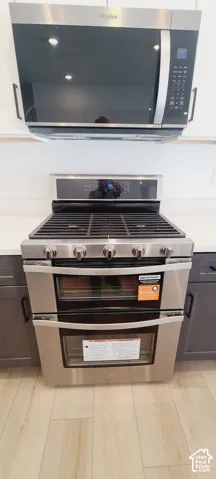 Stainless steel double oven range with gas cooktop, complemented by a stainless steel microwave
