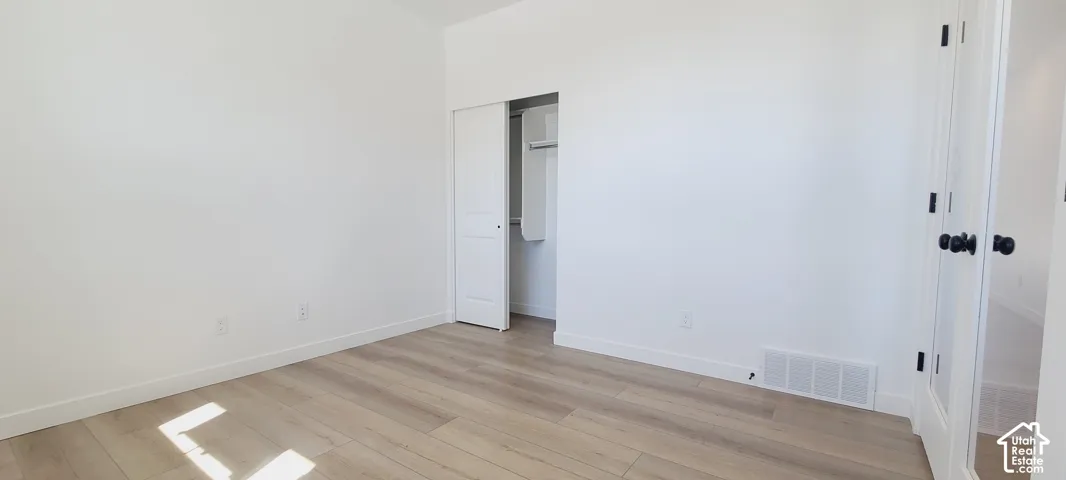 Light wood-finish flooring with white walls