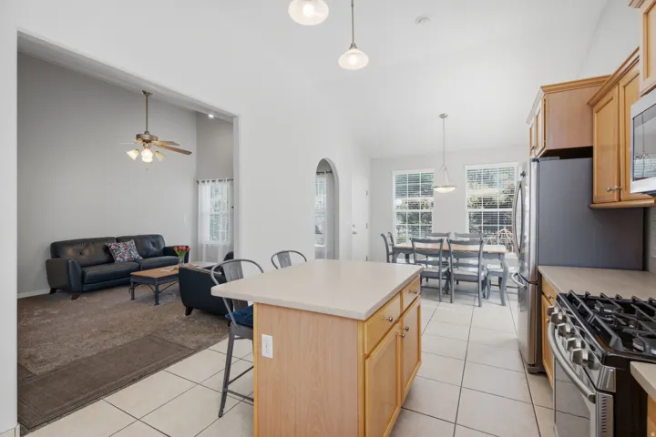 Kitchen with light wood cabinetry, a central island, and stainless steel appliances