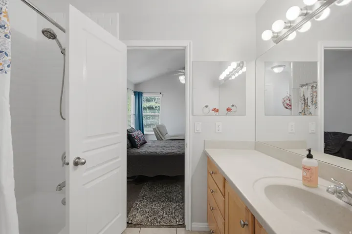 Vanity with light-toned countertop, integrated sink, and wood-finish cabinetry