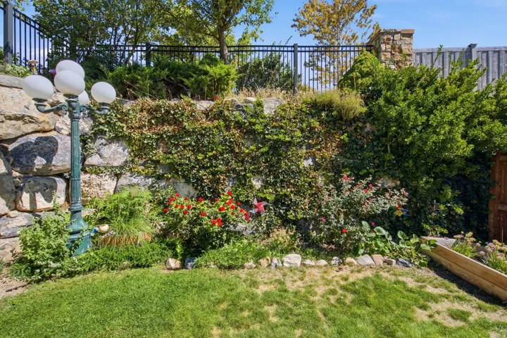 Tiered stone retaining wall with established plantings