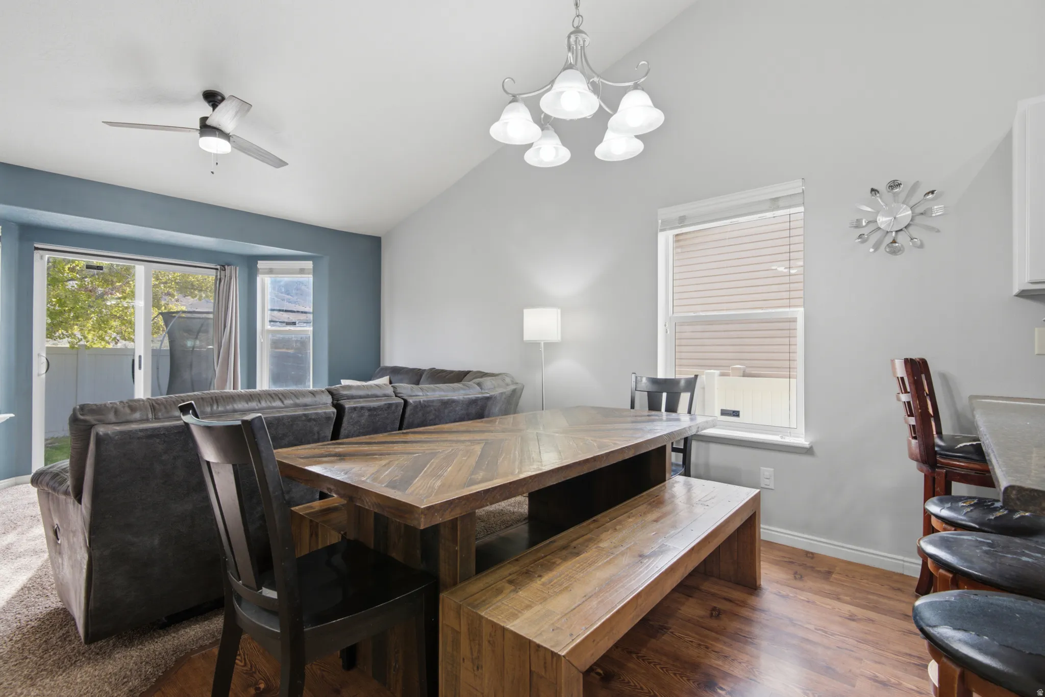 Vaulted ceiling, wood-finish flooring, built-in recessed bay, and a glass sliding door