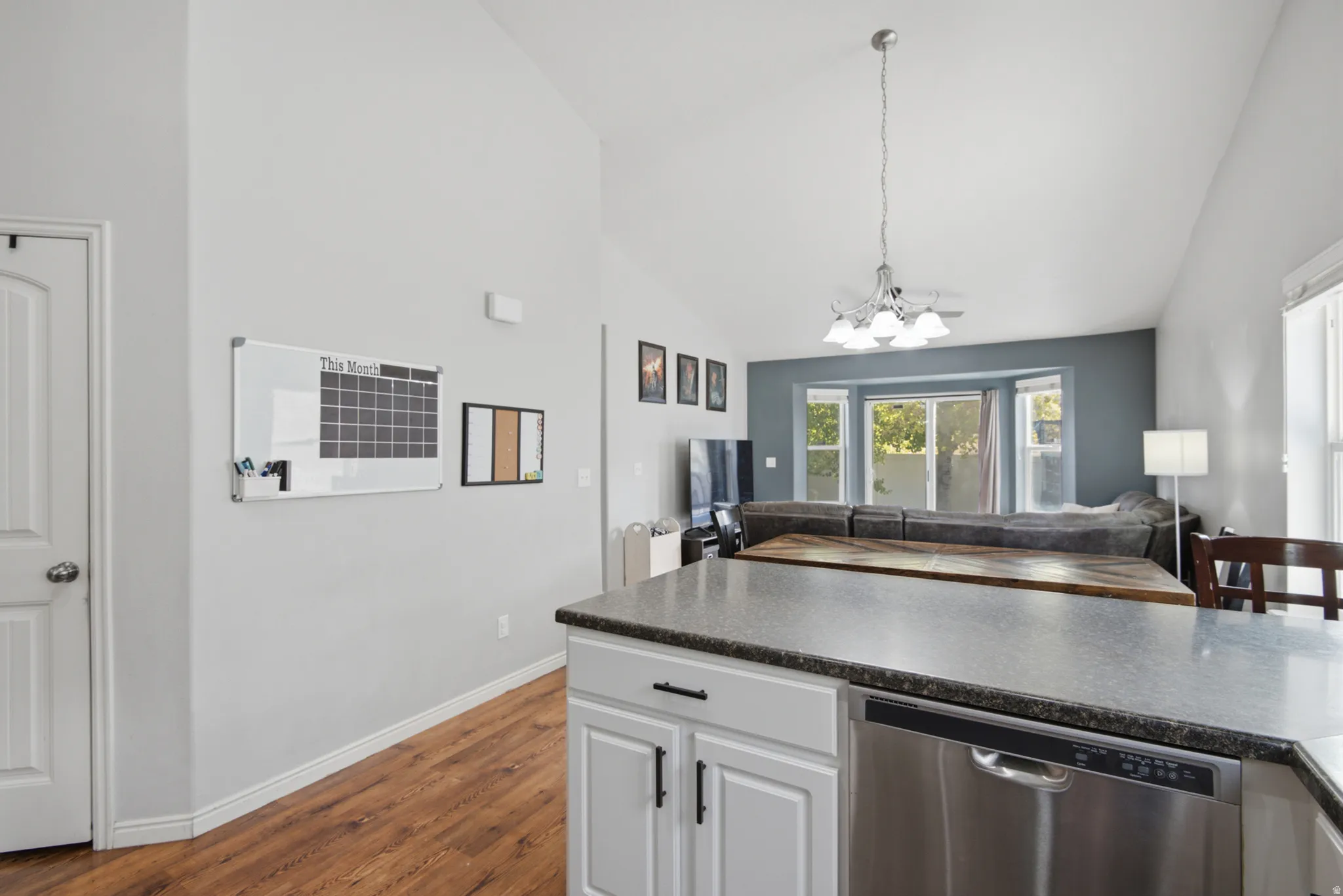 Kitchen island with dark countertop and stainless steel dishwasher