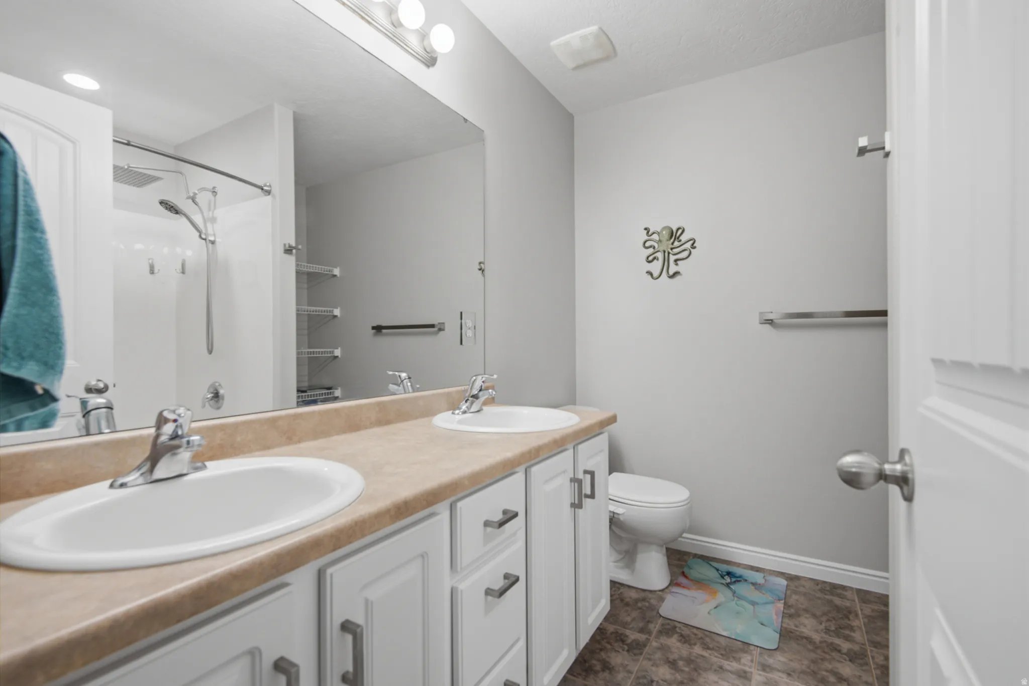 Dual vanity with undermount sinks, white cabinetry, and brushed nickel hardware