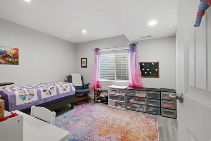 Recessed lighting, light gray walls, window with blinds, wood-finish flooring, and a white interior door