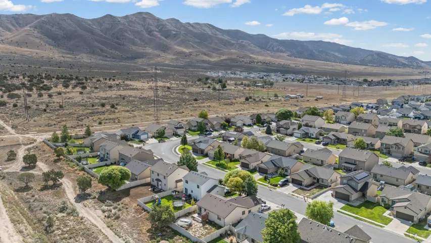 Residential neighborhood with paved streets and established homes, set against a backdrop of distant mountains