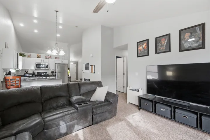 Vaulted ceilings with recessed lighting, ceiling fan, and chandelier