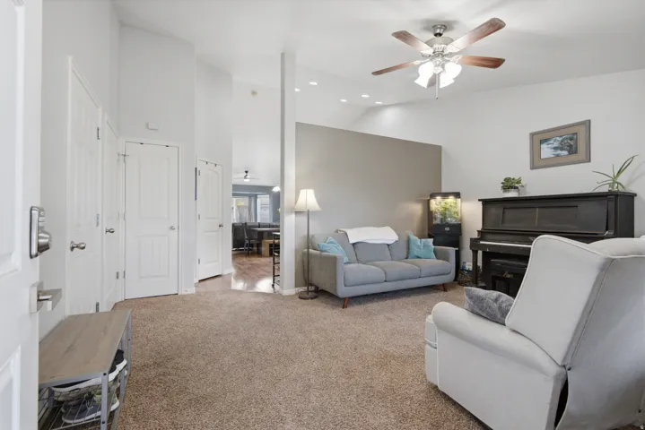 Vaulted ceilings with recessed lighting and a ceiling fan, plush carpet flooring, and white interior doors