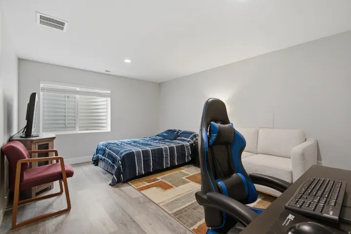 Recessed lighting, light gray walls, window with horizontal blinds, wood-finish flooring, and white trim