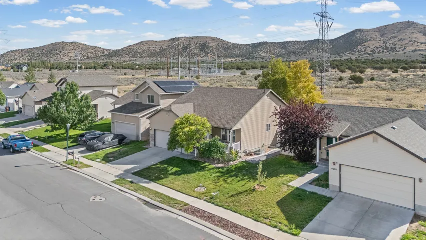 Single-story home featuring an attached two-car garage, established landscaping, and a paved driveway