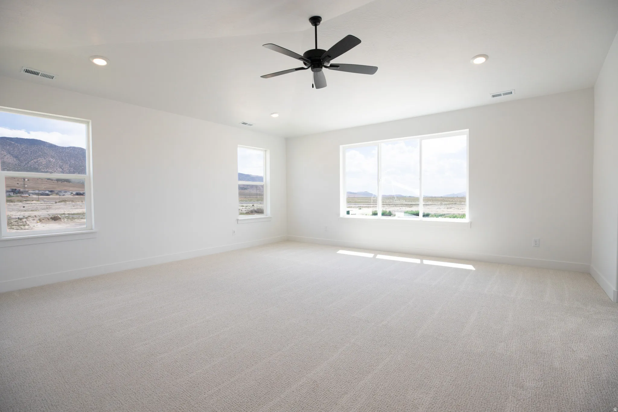Spacious primary bedroom with vaulted ceiling and ceiling fan.