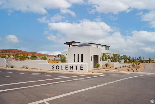 Entry monument featuring modern architecture, white stucco finish, and integrated landscaping