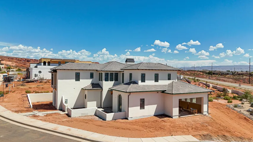 White stucco exterior with a multi-level structure, a covered patio, and a tile roof