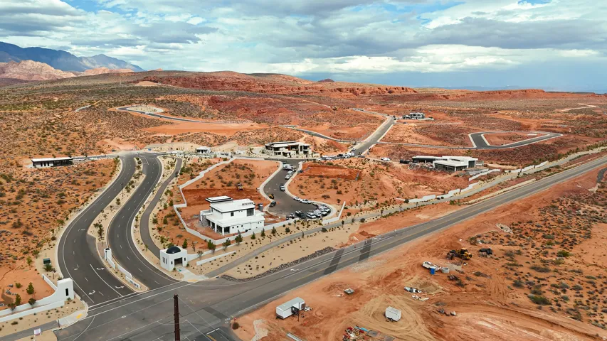 Winding roads with integrated hardscaping, contemporary homes, and expansive undeveloped parcels