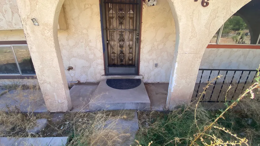 Archway entry with stucco finish and security screen door